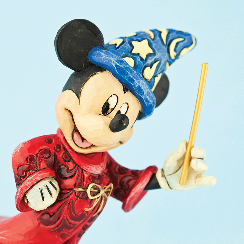 Wooden statue of micky mouse in a wizards hat and holding a wand.