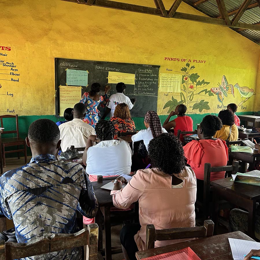 Yellow walled classroom with teachers looking to the front