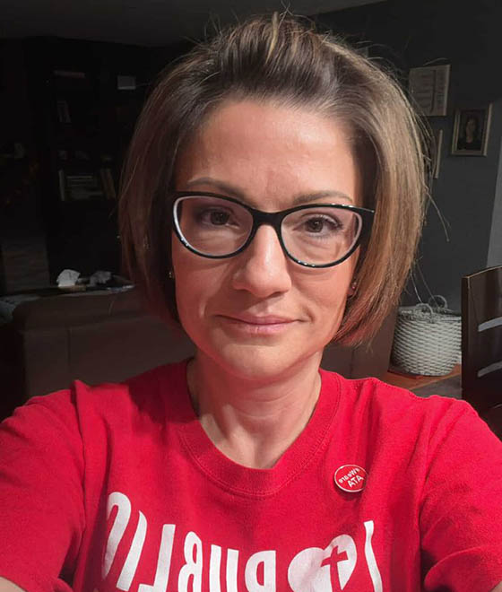 Selfie of a women wearing glasses in her red I love Public Ed shirt