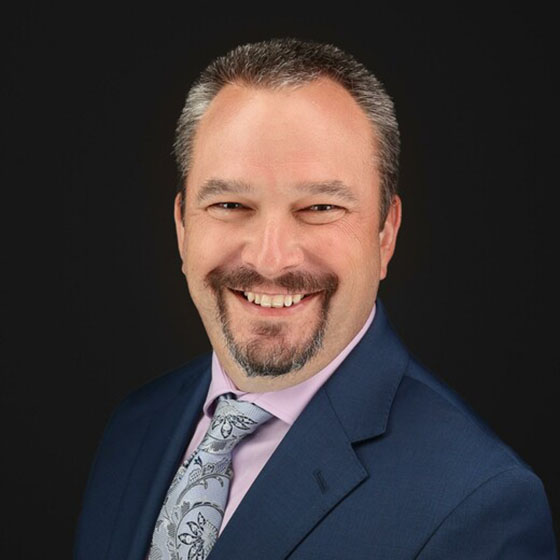 Portrait of man with goatee in a blue suit