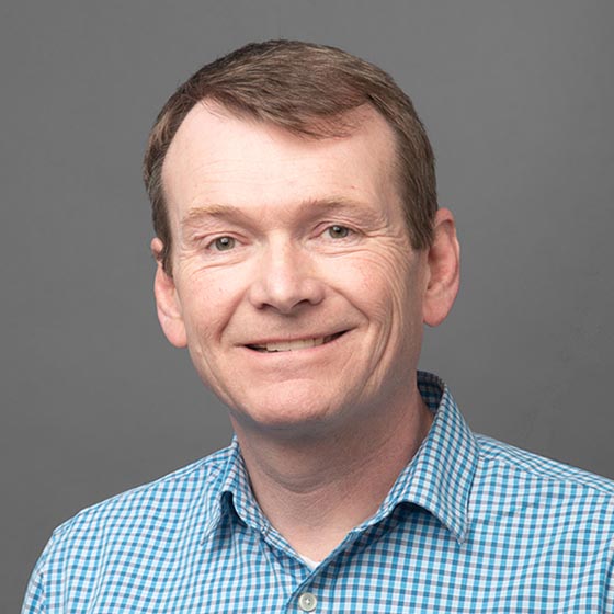 Portrait of a smiling man in a blue gingham shirt