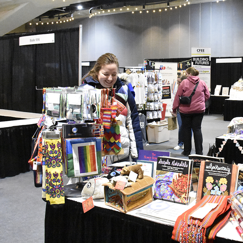 A woman looks at items available at a booth at a convention