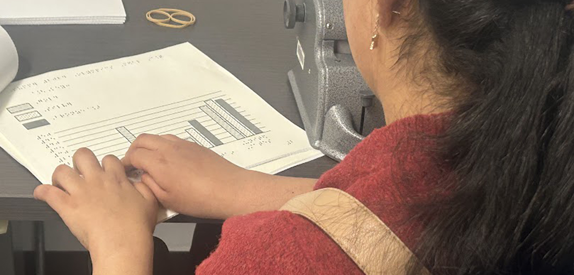 Student at desk reading braille 