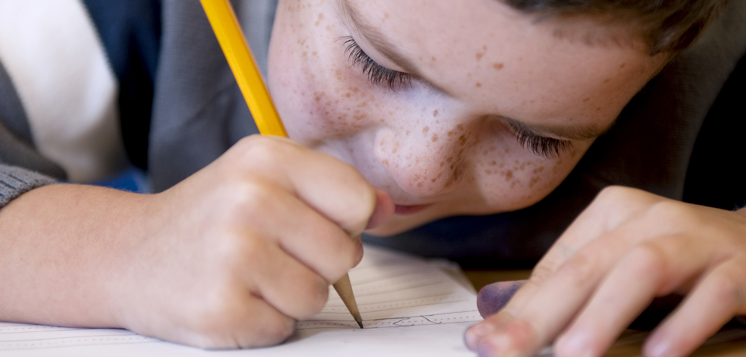 Close up of a child writing an exam
