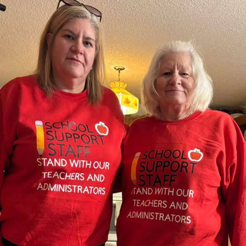 Two teachers wearing school support staff t-shirts