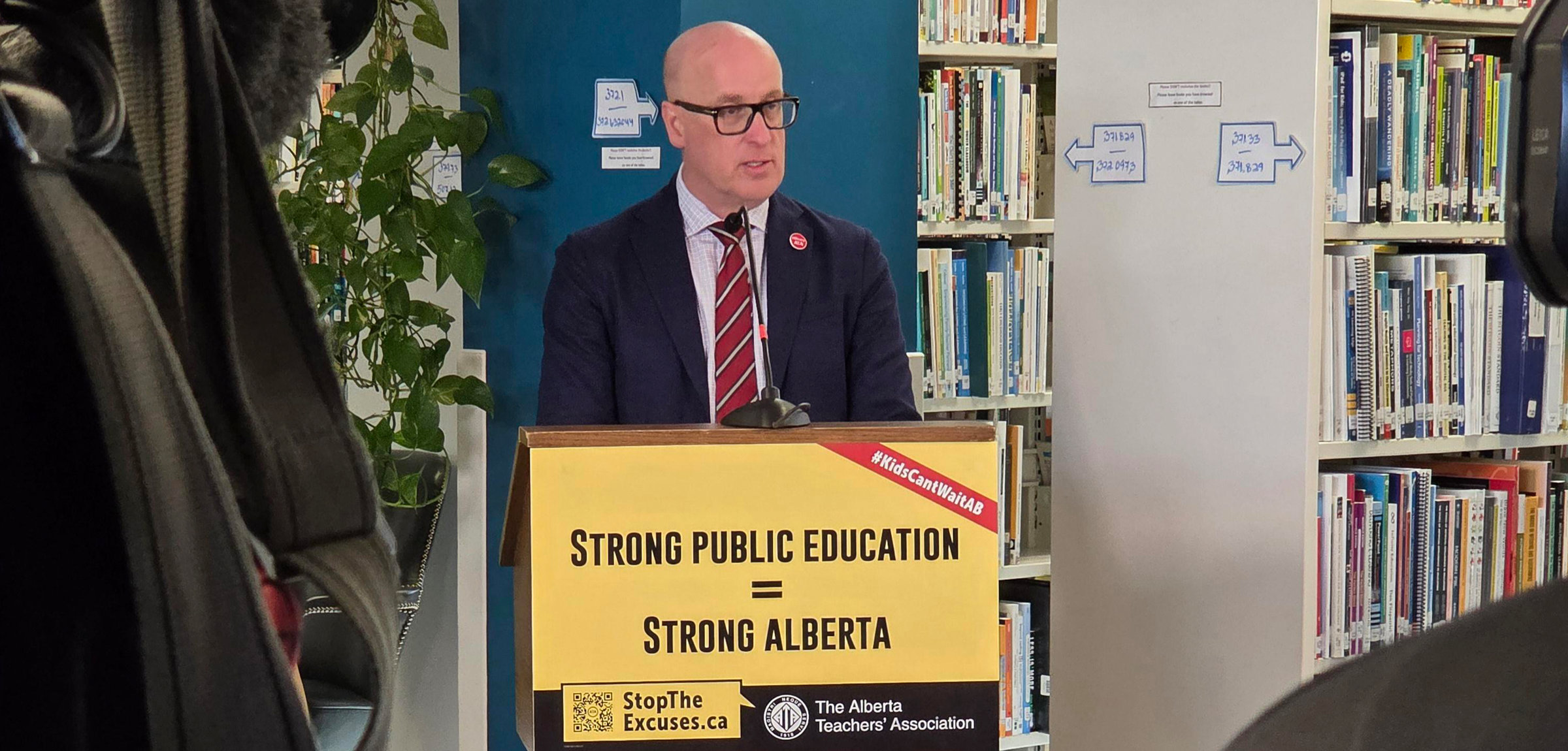 A passionate man speaking at a podium in a library