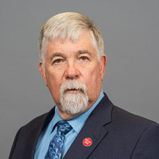 A man with white hair and a white goatee