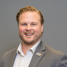 A smiling, beared man with auburn hair