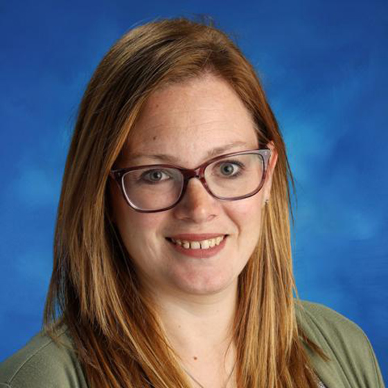 Portrait photo of a women with red hair wearing glasses