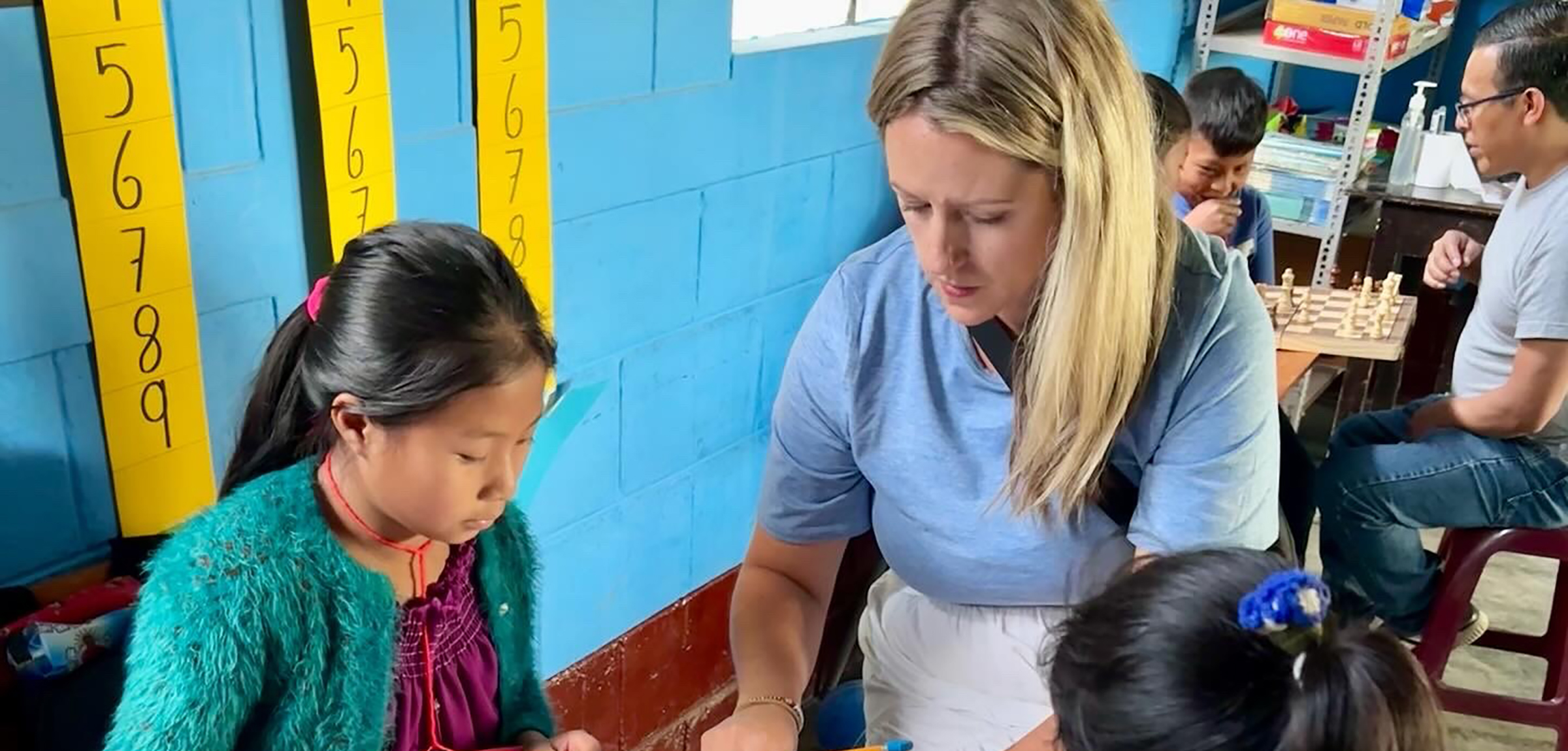 A teacher explains a math lesson to Guatemalan students