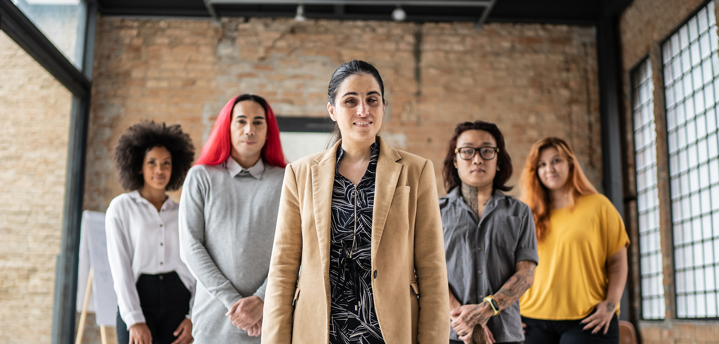 Group of individuals standing in a flying V in a warehouse