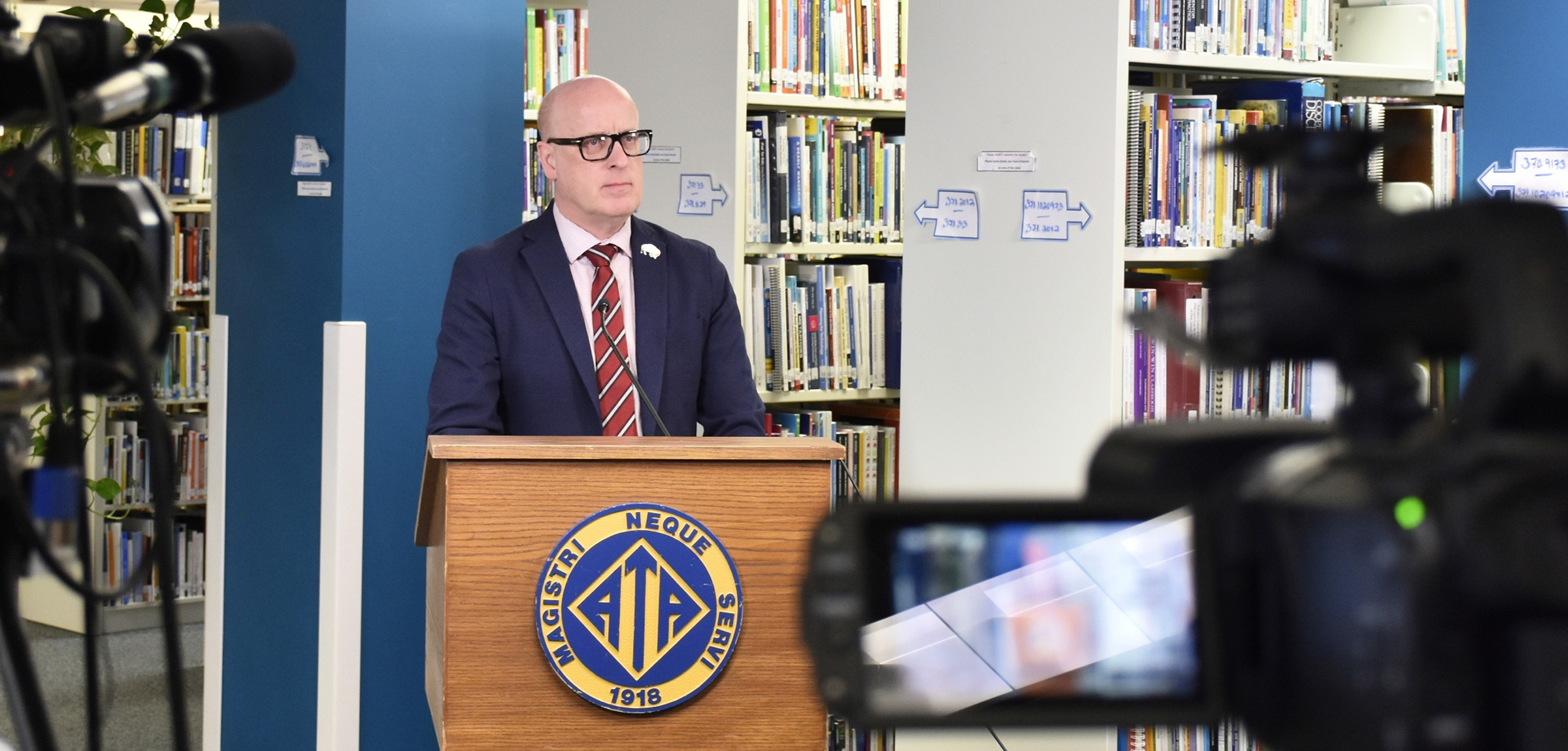 ATA president Jason Schilling standing at a podium in the Barnett House library