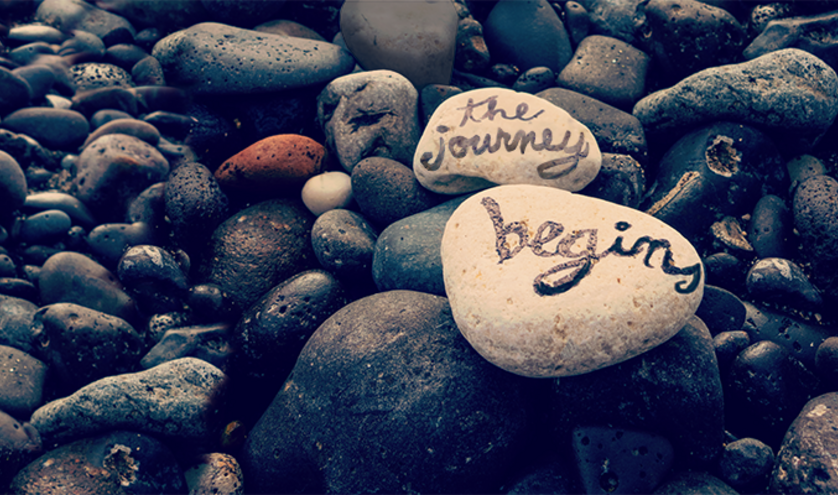 "The Journey Begins" written on rocks