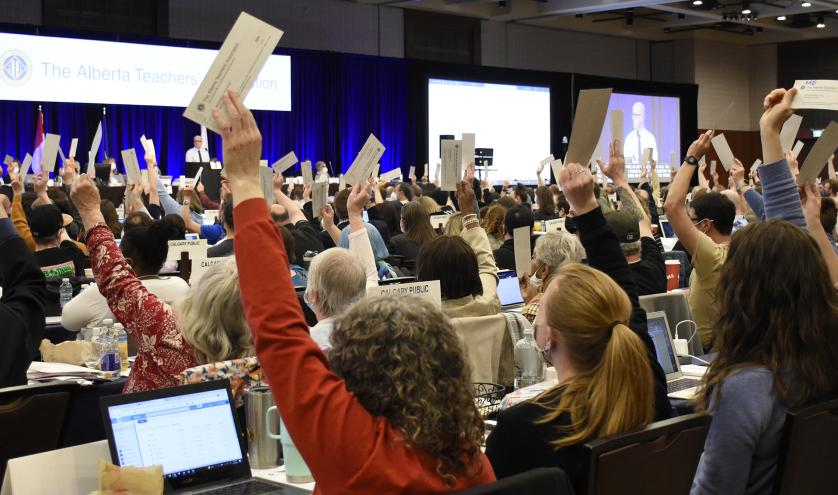 Room full of individuals voting with their hands raised at the 2022 Annual Representative Assembly