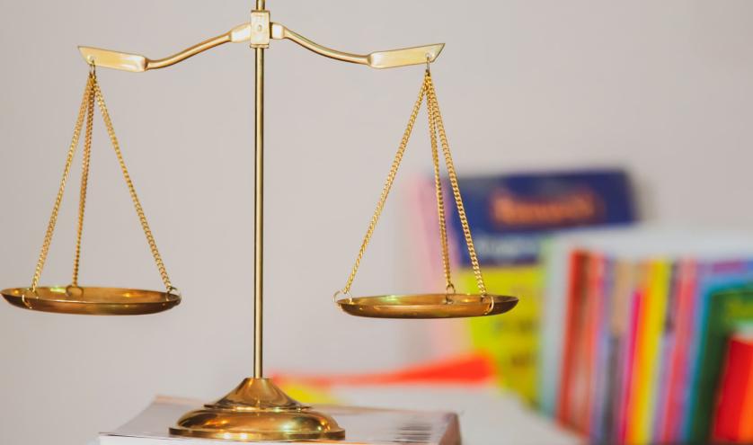 Brass scales in front of a row of colorful books