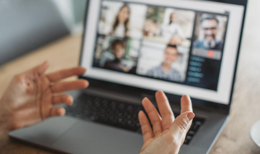 Someone explaining with their hands to a group online chat