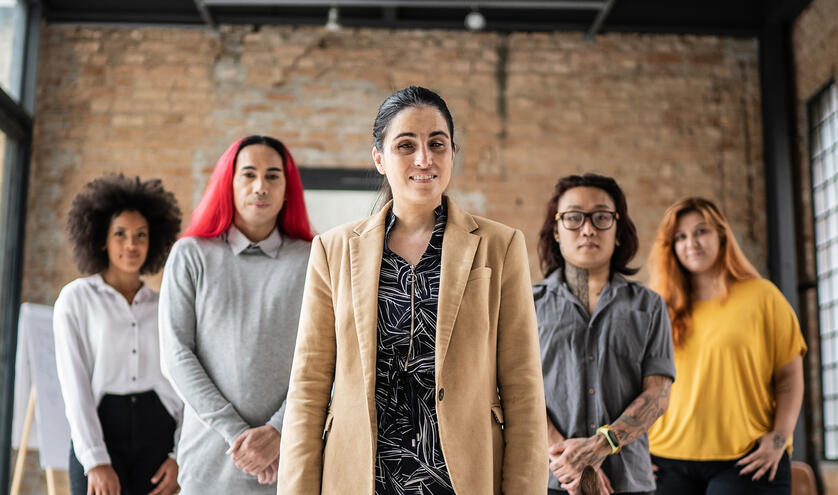 Group of individuals standing in a flying V in a warehouse