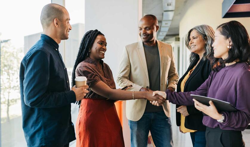 Multiracial group shaking hands and smiling