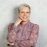 Women in pink top with short blonde hair