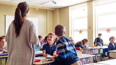 Teacher standing in front of a class of young students