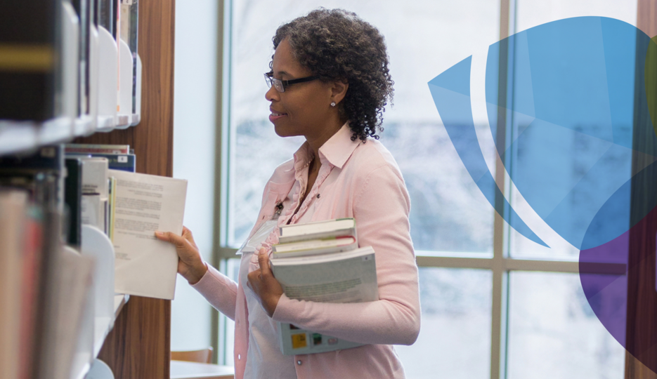 Women standing library restacking the shelves 