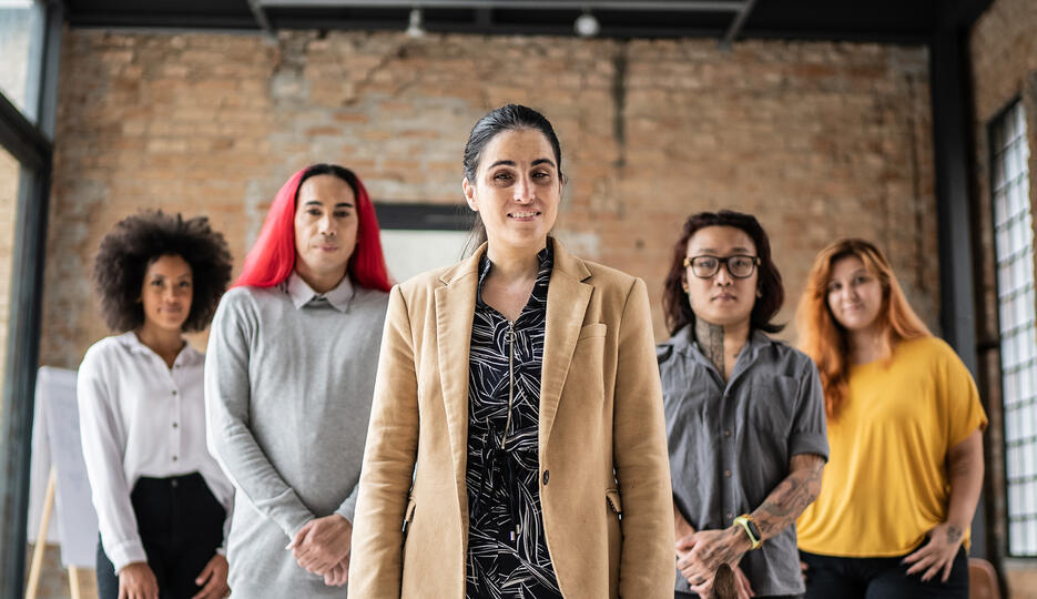 Group of individuals standing in a flying V in a warehouse