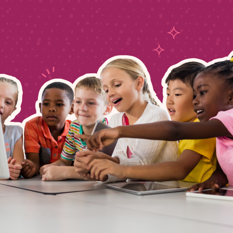 Children gathered around a table listening to their teacher.