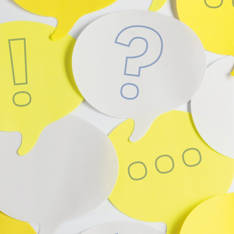 White and yellow speech bubble post-it notes with hand drawn ellipses, question and exclamation marks,