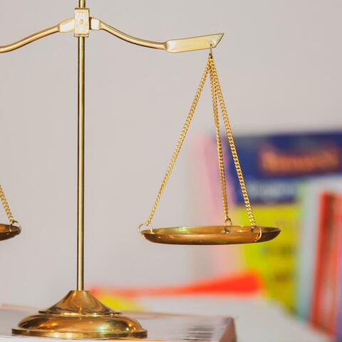 Brass scales in front of a row of colorful books