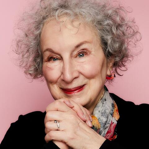 Women with curly grey hair clasping her hands at chin