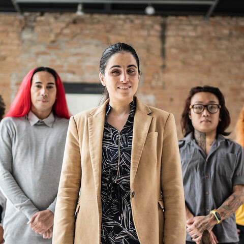 Group of individuals standing in a flying V in a warehouse