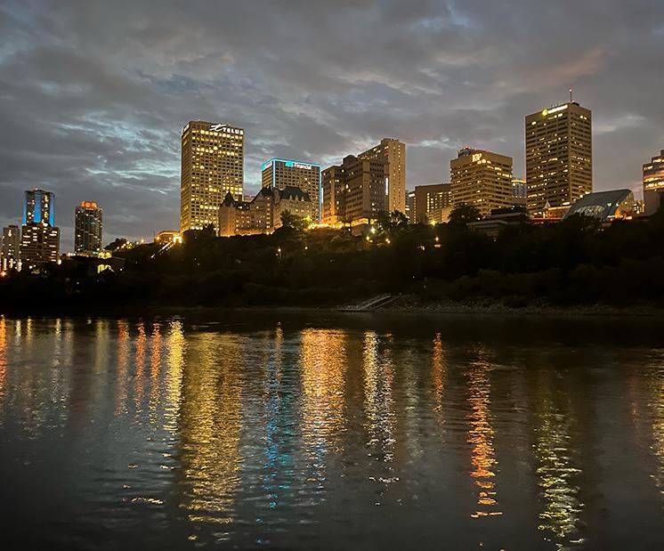 Edmonton skyline reflects on river at night 