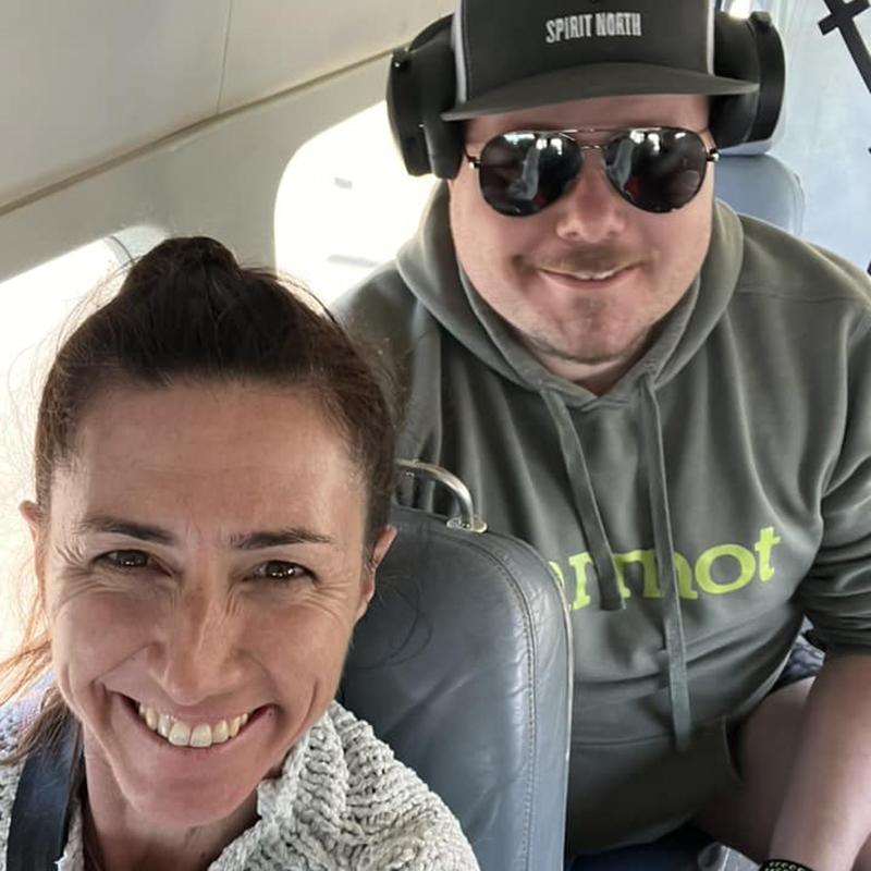 Teacher and school leader pose for a selfie while on a flight