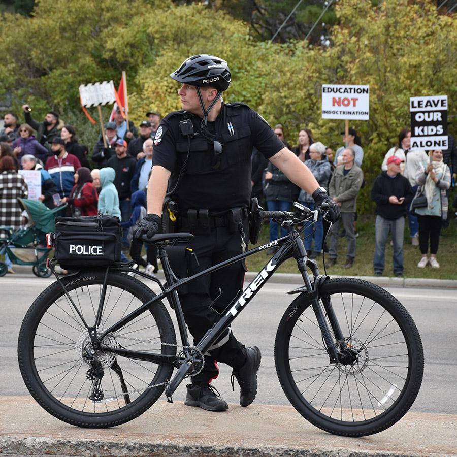 A police officer with a bicycle stand on a meridian in the middle of the road outside the ATA