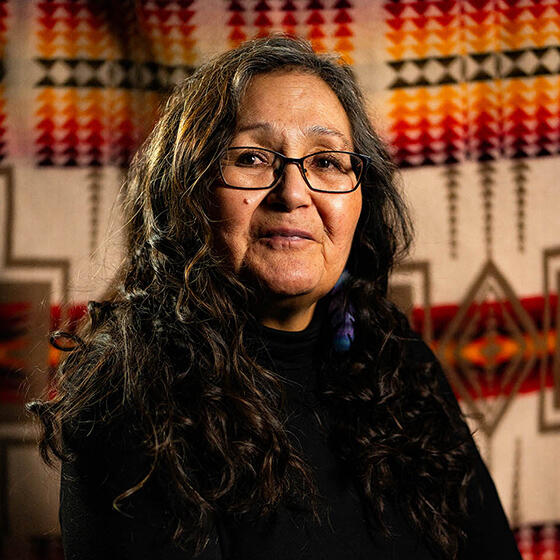 Indigenous women seated in front of a Pendleton Blanket