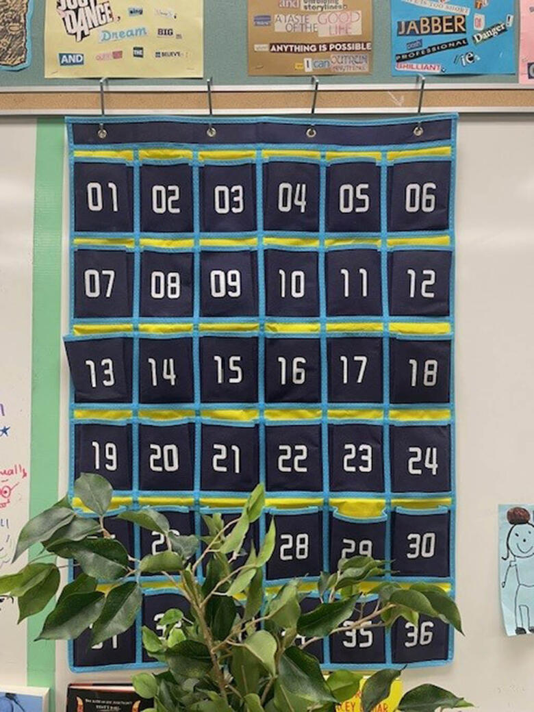 Numbered sleeves hang on the wall for students to put their cellphones