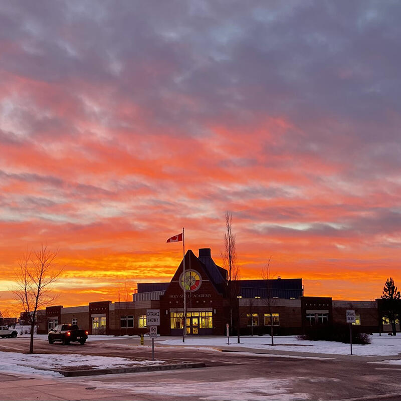 A vivid sunrise behind a school