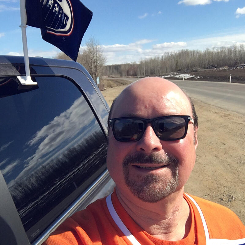 A man takes a selfie while wearing an Oilers jersey