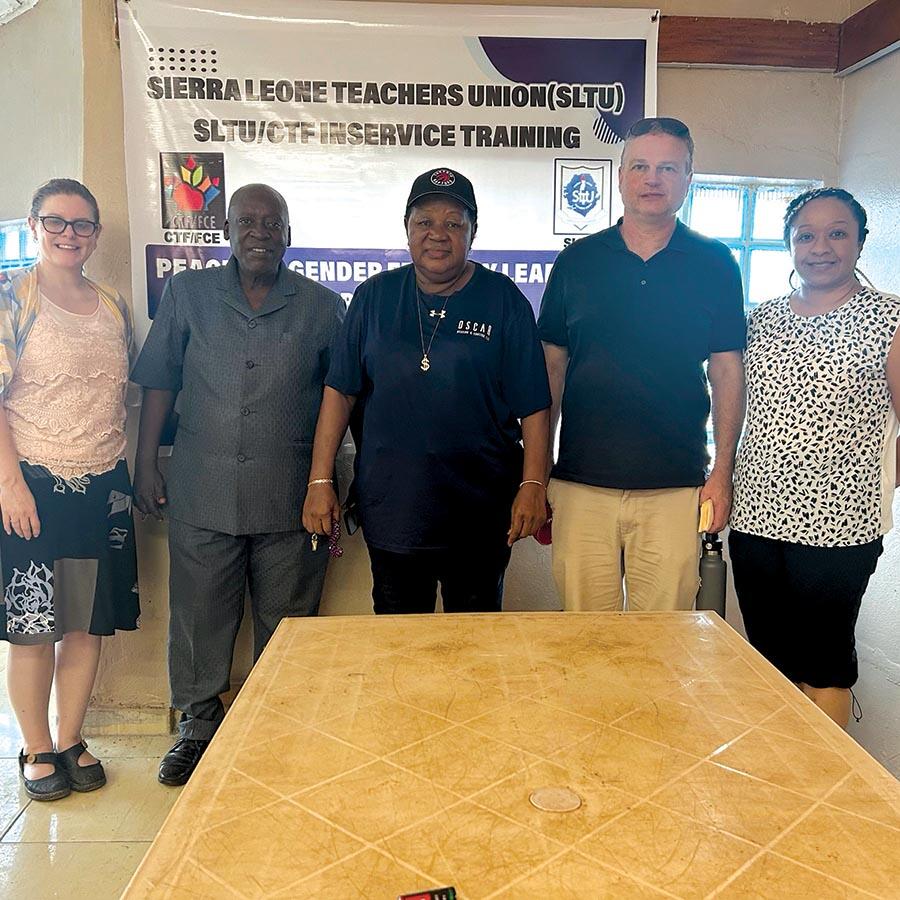 Five teachers stand pose infront of Sierra Leone Teachers Union sign