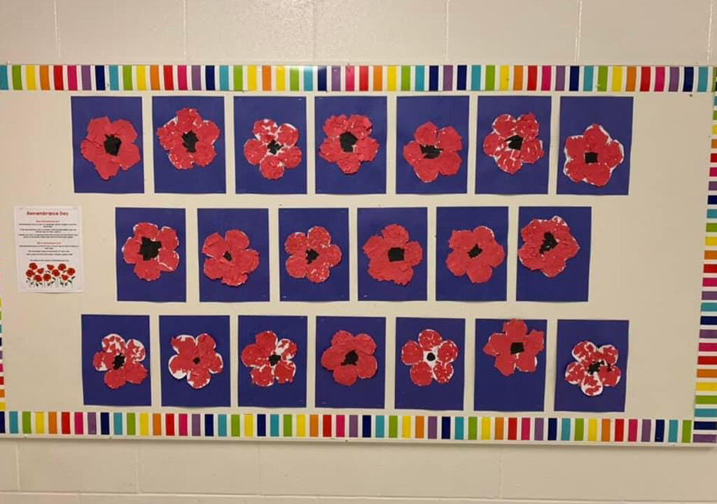 Student created poppies hanging on a wall