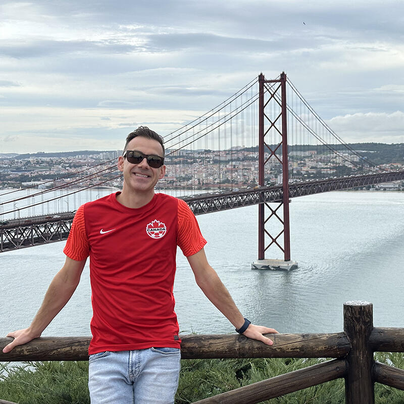 A man stands in front of the Golden Gate bridge