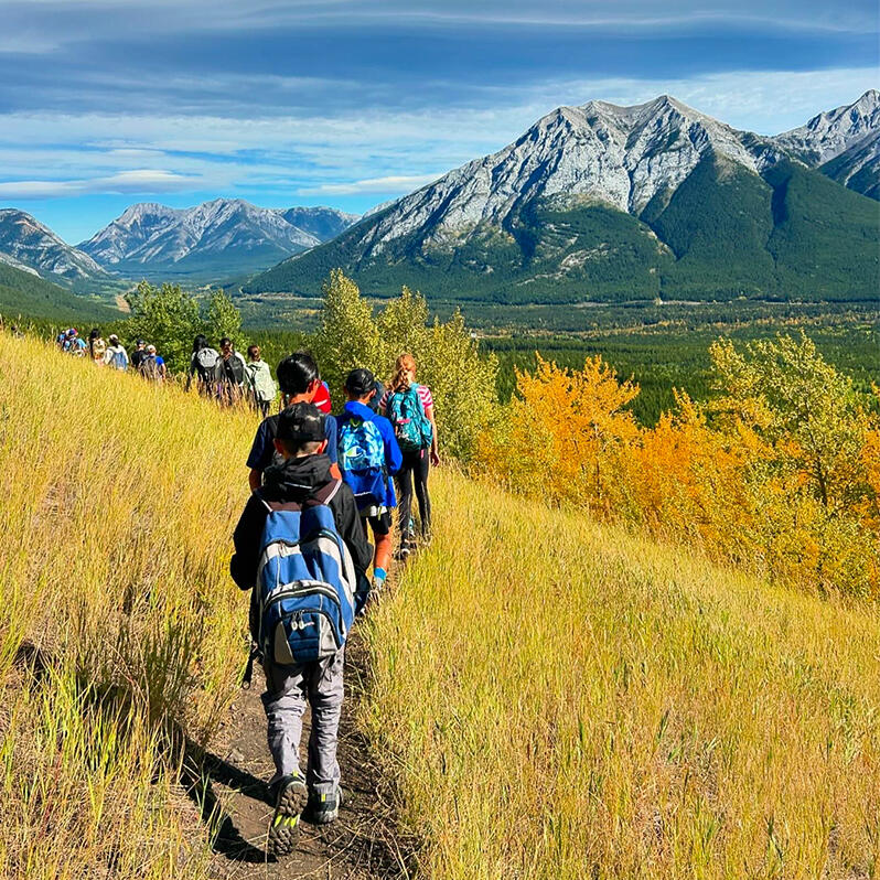 Students hike along a trail in the mountains