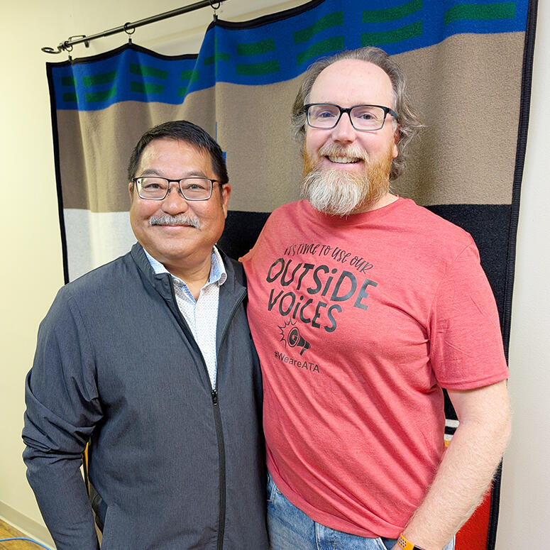 A person wearing a red shirt standing next to their MLA Rob Miyashiro