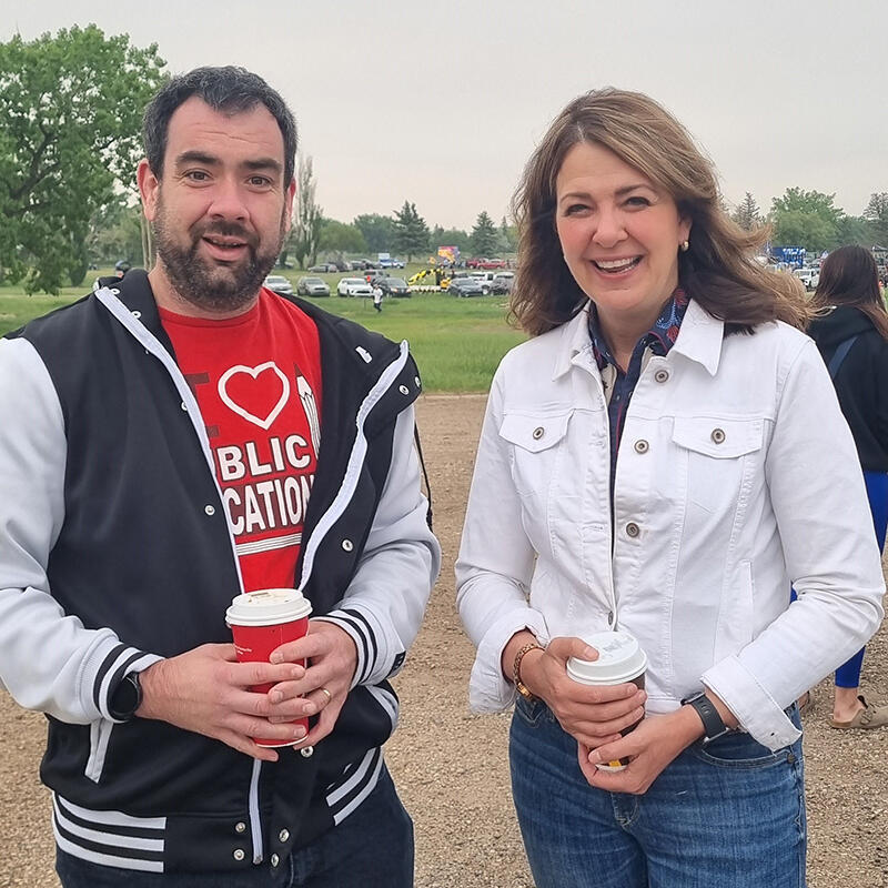 A person wearing a red shirt standing next to Premier Smith