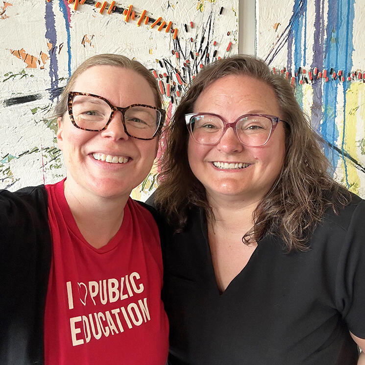 A person wearing a red shirt standing next to their MLA Sarah Hoffman