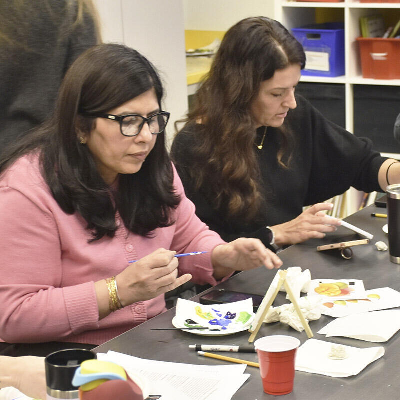 GETCA conference attendees painting on canvas at a table