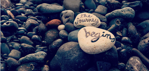 "The Journey Begins" written on rocks