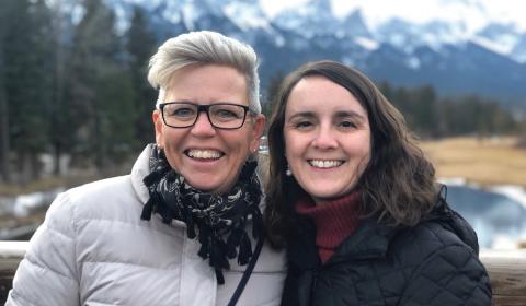 Two women posing in front of mountains