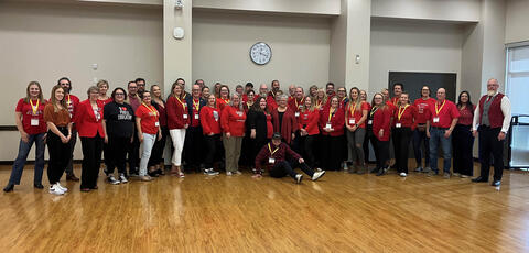 group of 25 people wearing red shirts in the ATA's auditorium