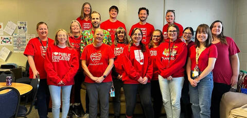 Teachers stand in their red t-shirts